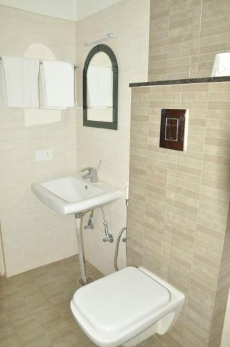 łazienka z toaletą i umywalką w obiekcie ZIONS APARTMENT w mieście Devanhalli