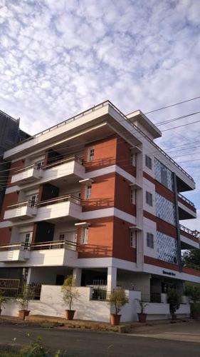 duży budynek apartamentowy po stronie ulicy w obiekcie ZIONS APARTMENT w mieście Devanhalli