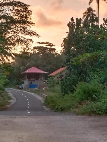 a road with a building on the side of the road at Rumah Nalu surf camp in Krui
