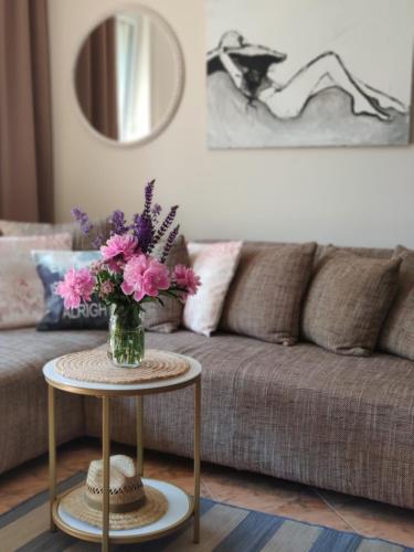 a vase of flowers on a table in front of a couch at Kołobrzeg Podczele 8A in Kołobrzeg