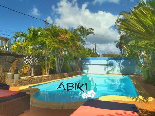 a swimming pool in a resort with palm trees at Maya-Abiki Mauritius in Albion