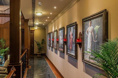 a hallway with a bunch of pictures on the wall at Raajkutir - IHCL SeleQtions in Kolkata
