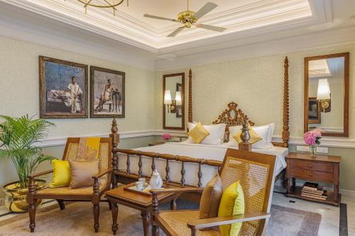 a bedroom with a large bed and two chairs at Raajkutir - IHCL SeleQtions in Kolkata