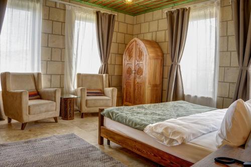 a bedroom with a bed and two chairs at IVY Cappadocia in Nevsehir