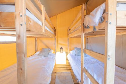 two bunk beds in a room with yellow walls at Luxury Glamping at Stags Head in Abbotskerswell