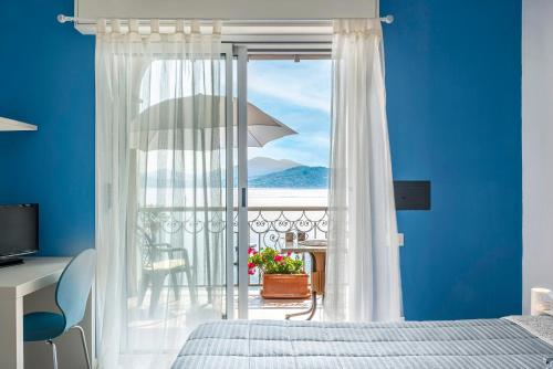 a bedroom with a window with a view of the ocean at Residence Casa e Vela in Oggebbio