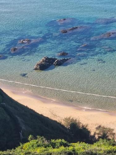an aerial view of a beach with rocks in the water at Arbus dune e mare in Arbus