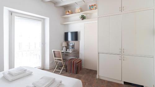 a white kitchen with white cabinets and a desk at Italianway - Argelati 2 in Milan