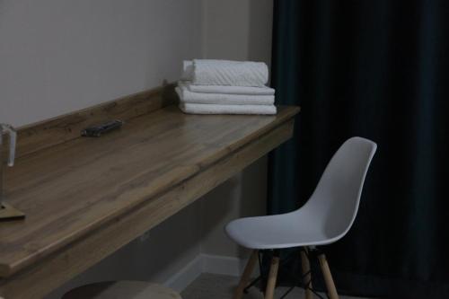 a pile of towels on a wooden counter with a white chair at Jardin in Aktobe