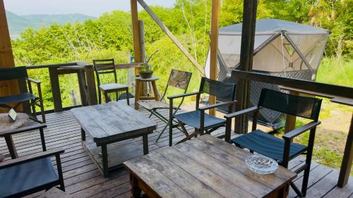 a group of chairs and tables on a deck at あしたのM 船でしか行けない離島のVilla in Hinase