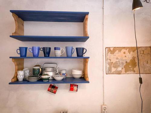 ein Regal mit blauen Tassen und Geschirr an der Wand in der Unterkunft Fairytale apartment in Viljandi old town in Viljandi
