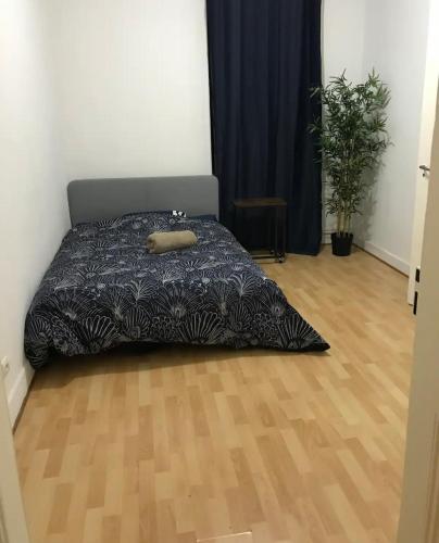 - une chambre avec un lit et du parquet dans l'établissement Appartement Spacieux à 10 min du centre, à Strasbourg