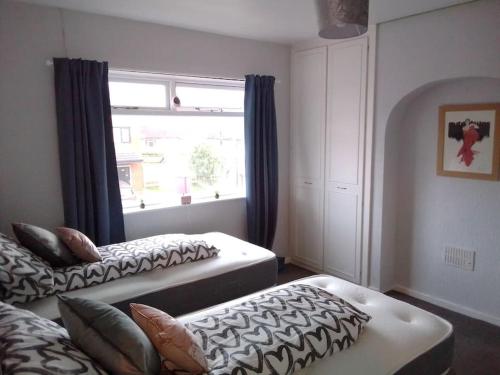 a bedroom with two beds and a window at Blackpool Holiday Home - Forshaw House in Blackpool