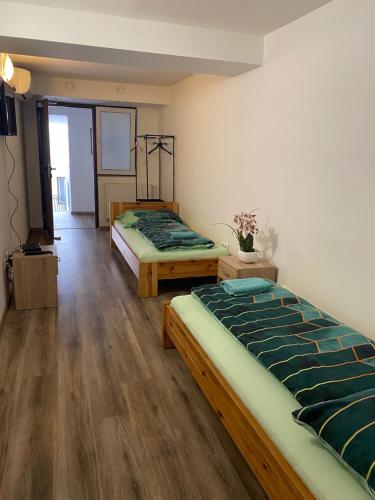 two beds in a room with wooden floors at Hostel Old Town in Bratislava