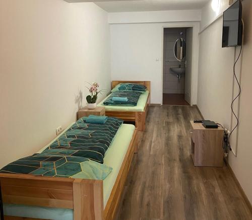 a room with two beds and a television in it at Hostel Old Town in Bratislava