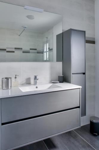 La cuisine blanche est équipée d'un évier et d'un réfrigérateur. dans l'établissement Maison moderne pour 6 - 500m plage de Pors Corn, à Penmarcʼh