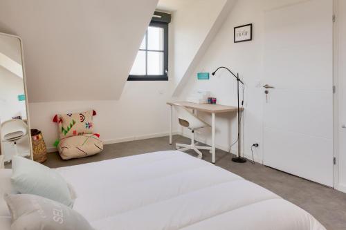 une chambre blanche avec un lit et un bureau dans l'établissement Maison moderne pour 6 - 500m plage de Pors Corn, à Penmarcʼh