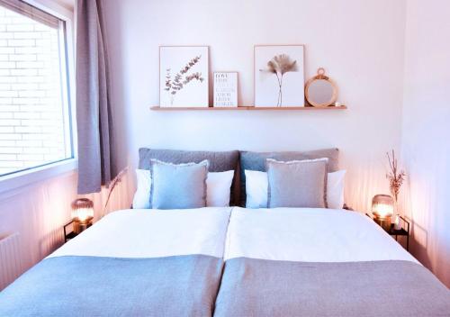 ein Schlafzimmer mit einem großen Bett mit blauen und weißen Kissen in der Unterkunft Apartment mit Balkon - Netflix - nahe Messe Düsseldorf in Krefeld