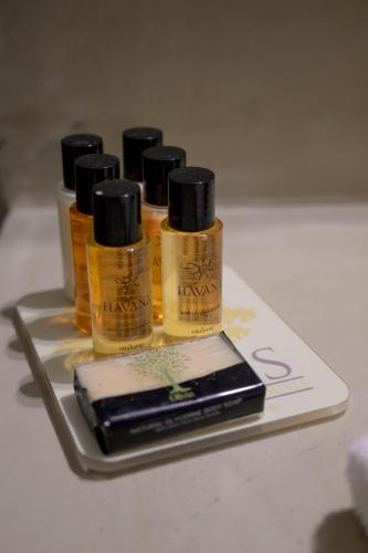 a tray with four bottles of shampoo and a cell phone at Oikies Small Elegant Houses in Mytilini