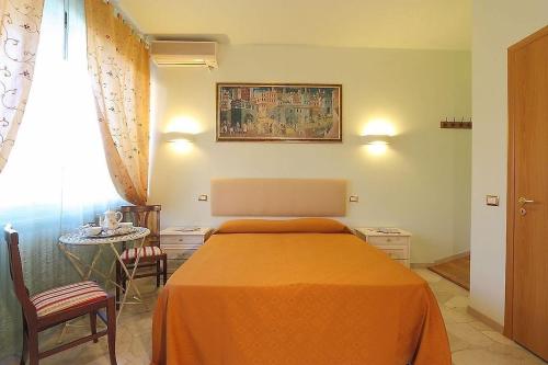Arcadia GuestHouse في فلورنسا: غرفة نوم مع سرير وبطانية برتقالية