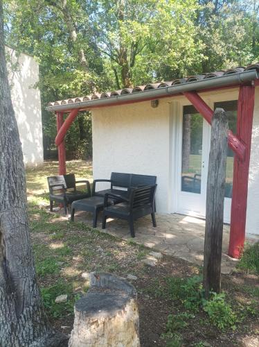 two benches sitting on a patio in front of a house at 7-gîte-7 personnes au cœur de la nature /piscine in Saint-Aubin-de-Nabirat