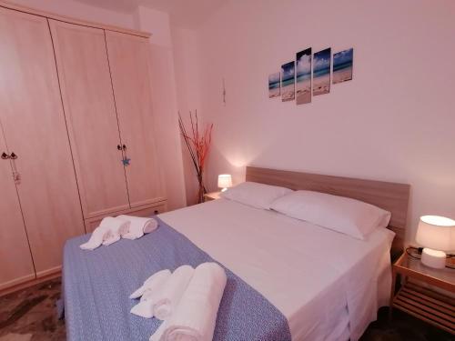 Un dormitorio con una cama con toallas. en Casa Diamante, a 50mt dal mare, en Santa Cesarea Terme