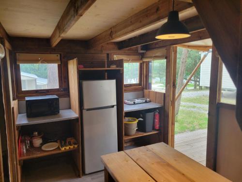 une cuisine avec un réfrigérateur et une table dans une maison dans l'établissement Camping Borepo, à Villeveyrac