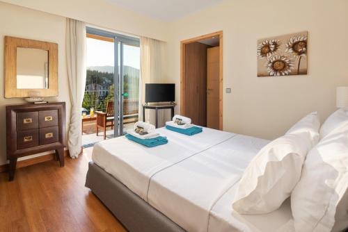 Un dormitorio con una gran cama blanca y una ventana en Villa Serena, Eastern Corfu en Kato Korakiana