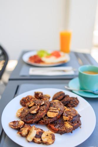 a plate of cookies on a table with a cup of coffee at Aerno Home & Azul Ηοme - Ahilli Slow Living in Kamari