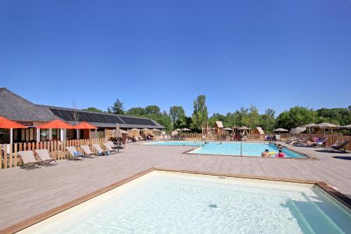 uma piscina num resort com cadeiras e pessoas em CityKamp Angers em Angers