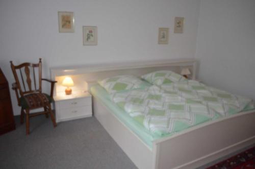 a small bedroom with a bed and a chair at Ferienwohnungen Ehlers-Bastelstudio in Bad Bevensen