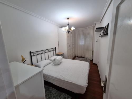 een kleine slaapkamer met 2 bedden en een hal bij Bajo con Jardin en Cartes in Cartes