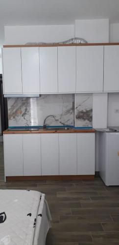a kitchen with white cabinets and a bath tub at Joy Summer Apartment in Skataj