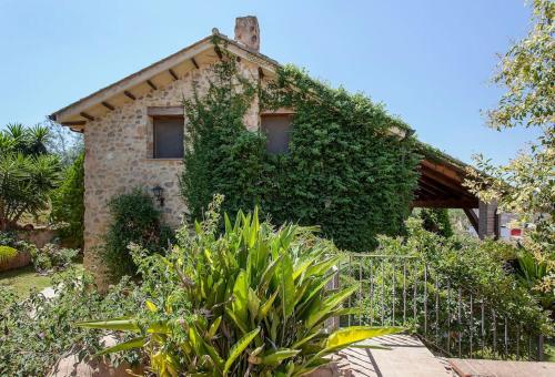 Una casa de piedra con hiedra a un lado. en VILLA TAMARIT, en Pedralba