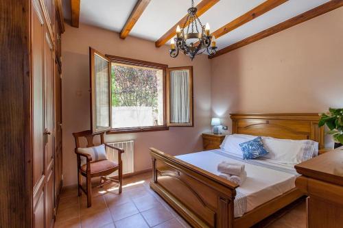 een slaapkamer met een bed, een stoel en een raam bij VILLA TAMARIT in Pedralba