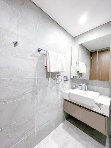 a white bathroom with a sink and a mirror at Apartment 1BR FL28th-Ruby-Vinhomes Ocean Park in Hanoi