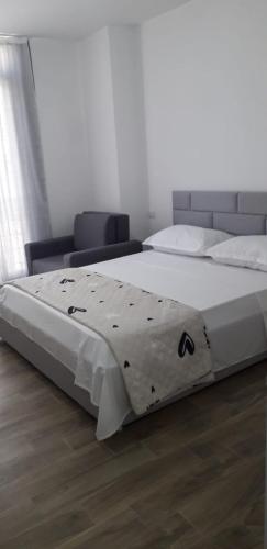 a bedroom with a bed with a comforter on it at Joy Summer Apartment in Skataj