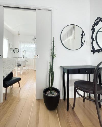 a dining room with a table and a potted plant at The White Cottage Byron Bay in Suffolk Park