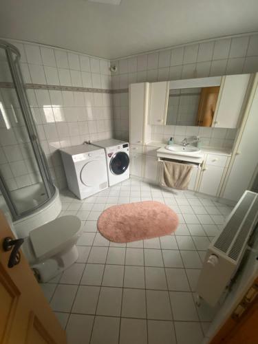 a bathroom with a washing machine and a sink at Fischerdorf-Fewo in Kalkar