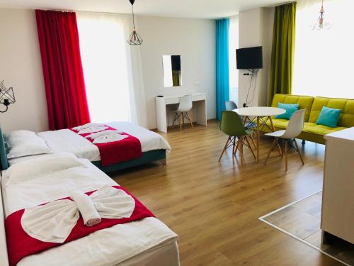 Habitación de hotel con 2 camas, mesa y sillas en Colors Boutique en Obzor