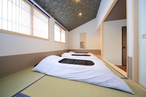 uma cama grande num quarto com janelas em 柏・清水2（Haku Kiyomizu2） em Quioto