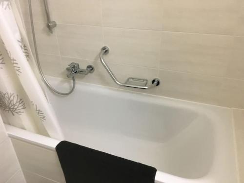 eine weiße Badewanne mit einem Wasserhahn im Bad in der Unterkunft Appartement meublé proche de la Gare de Lausanne 12 in Lausanne