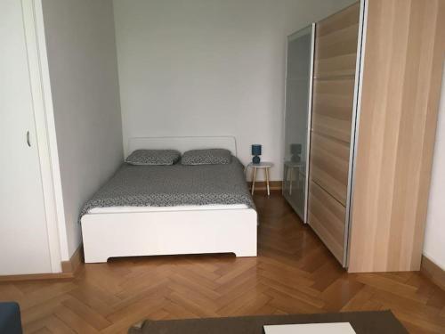 ein Schlafzimmer mit einem weißen Bett und einem Schrank in der Unterkunft Appartement meublé proche de la Gare de Lausanne 12 in Lausanne