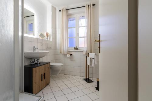 een witte badkamer met een wastafel en een toilet bij Friederike in Ahrenshoop