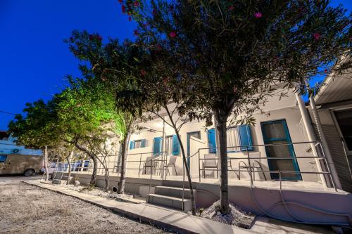 un edificio con finestre blu e alberi di fronte ad esso di Zante Riva Studios a Lithakia