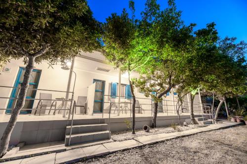 un bâtiment blanc avec des arbres devant lui dans l'établissement Zante Riva Studios, à Lithakia