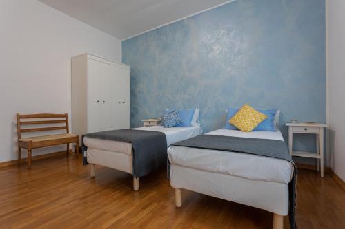 a bedroom with two beds and a chair at La Casa di Vitto by Wonderful Italy in Turin