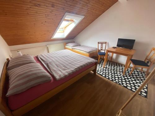 a bedroom with a bed and a desk with a laptop at R-Penzion in Český Krumlov