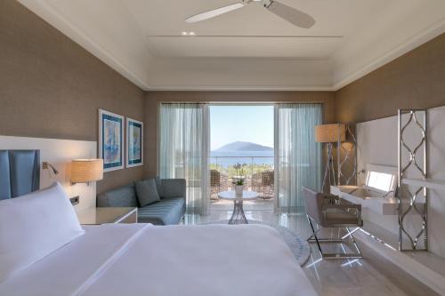 a hotel room with a bed and a view of the ocean at Caresse, a Luxury Collection Resort & Spa, Bodrum in Bitez