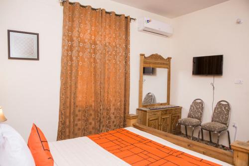 um quarto com uma cama, uma cómoda e um espelho em GOHO Garden View em Gilgit